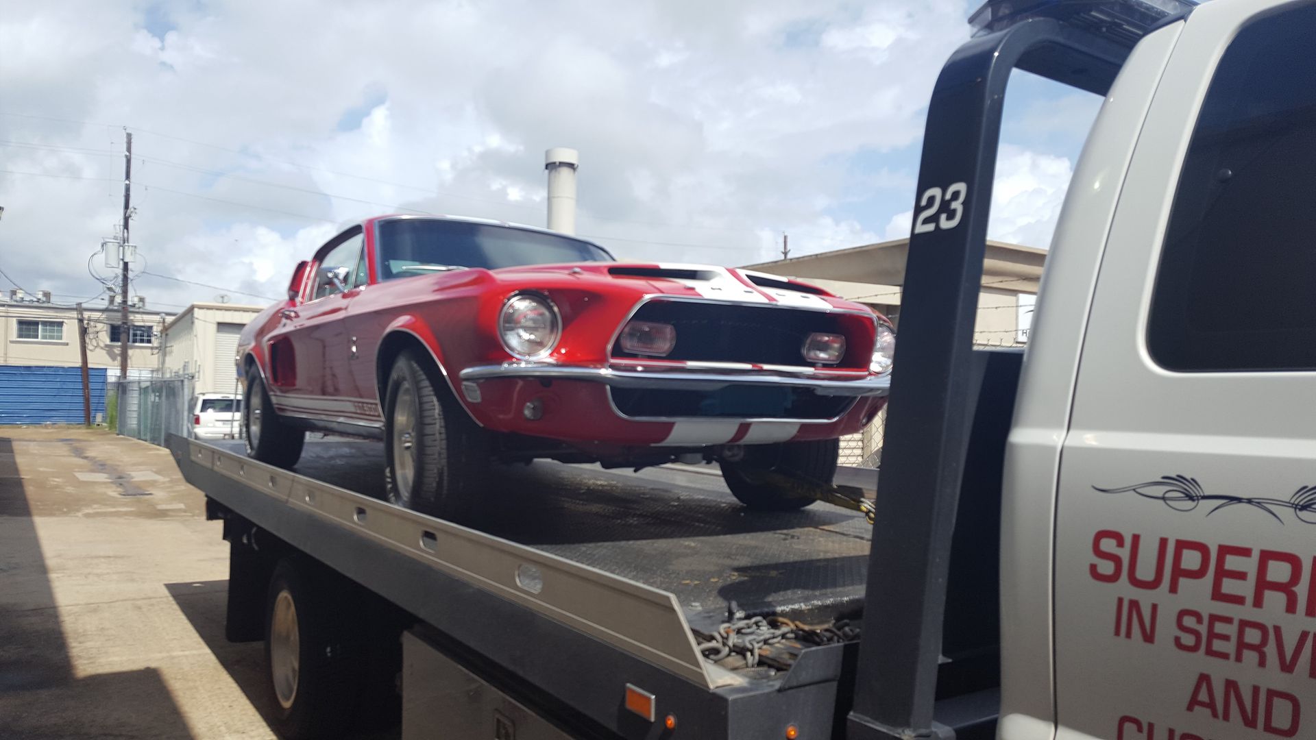 Red and white classic car on a flatbed tow truck