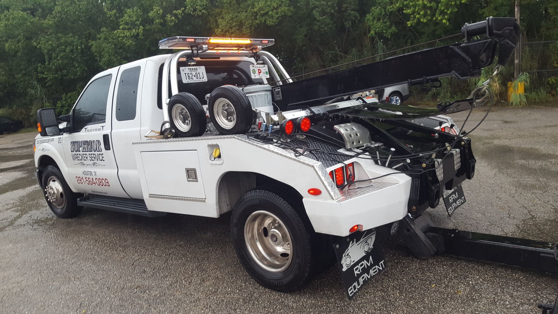 White tow truck with black boom parked outside