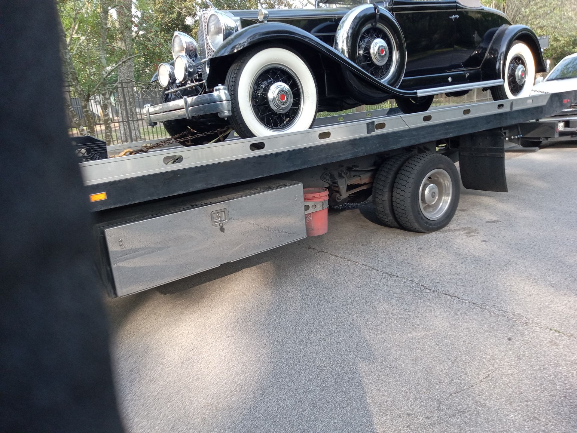 Black vintage car on a flatbed tow truck