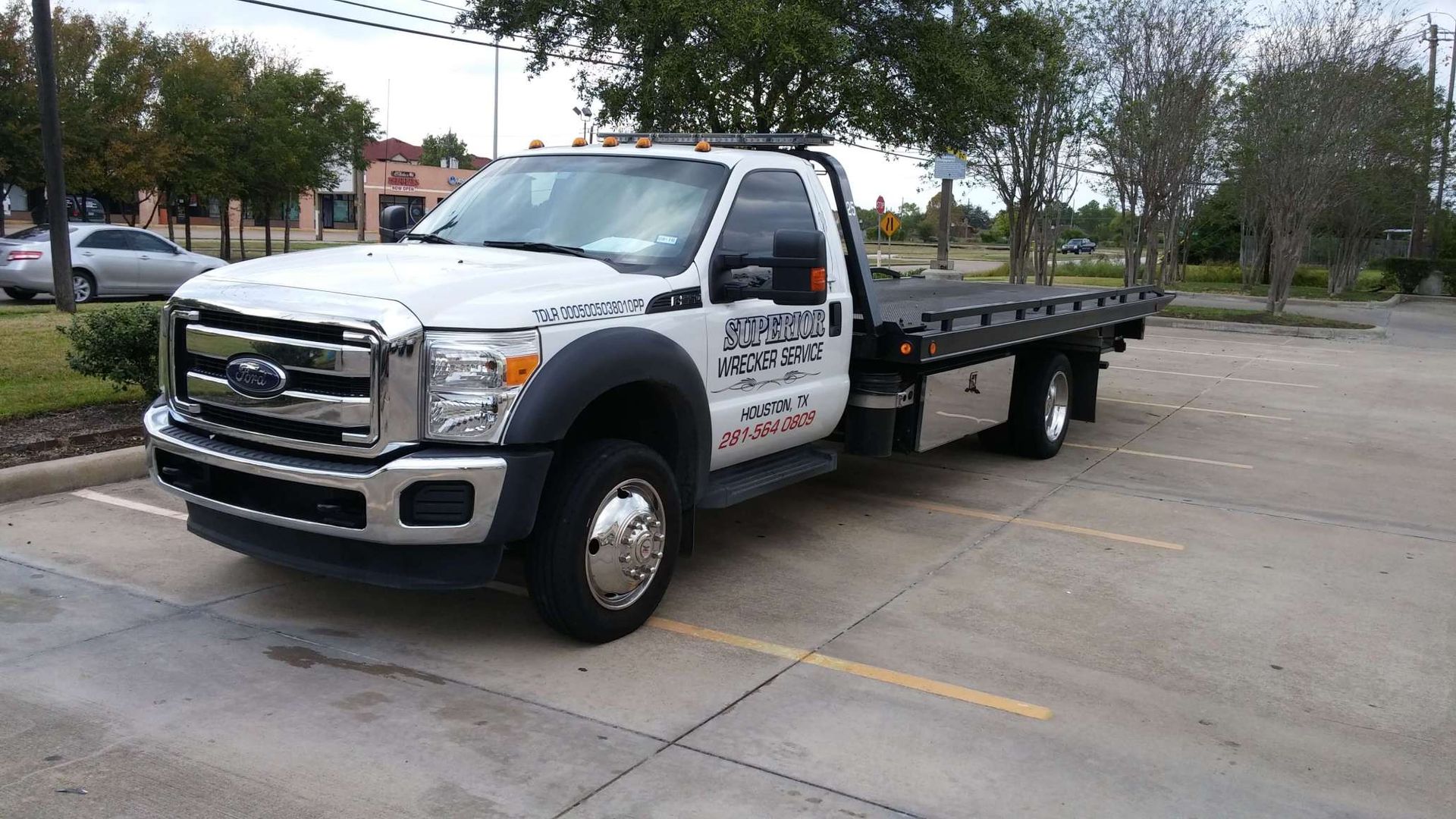 White tow truck parked in a parking lot