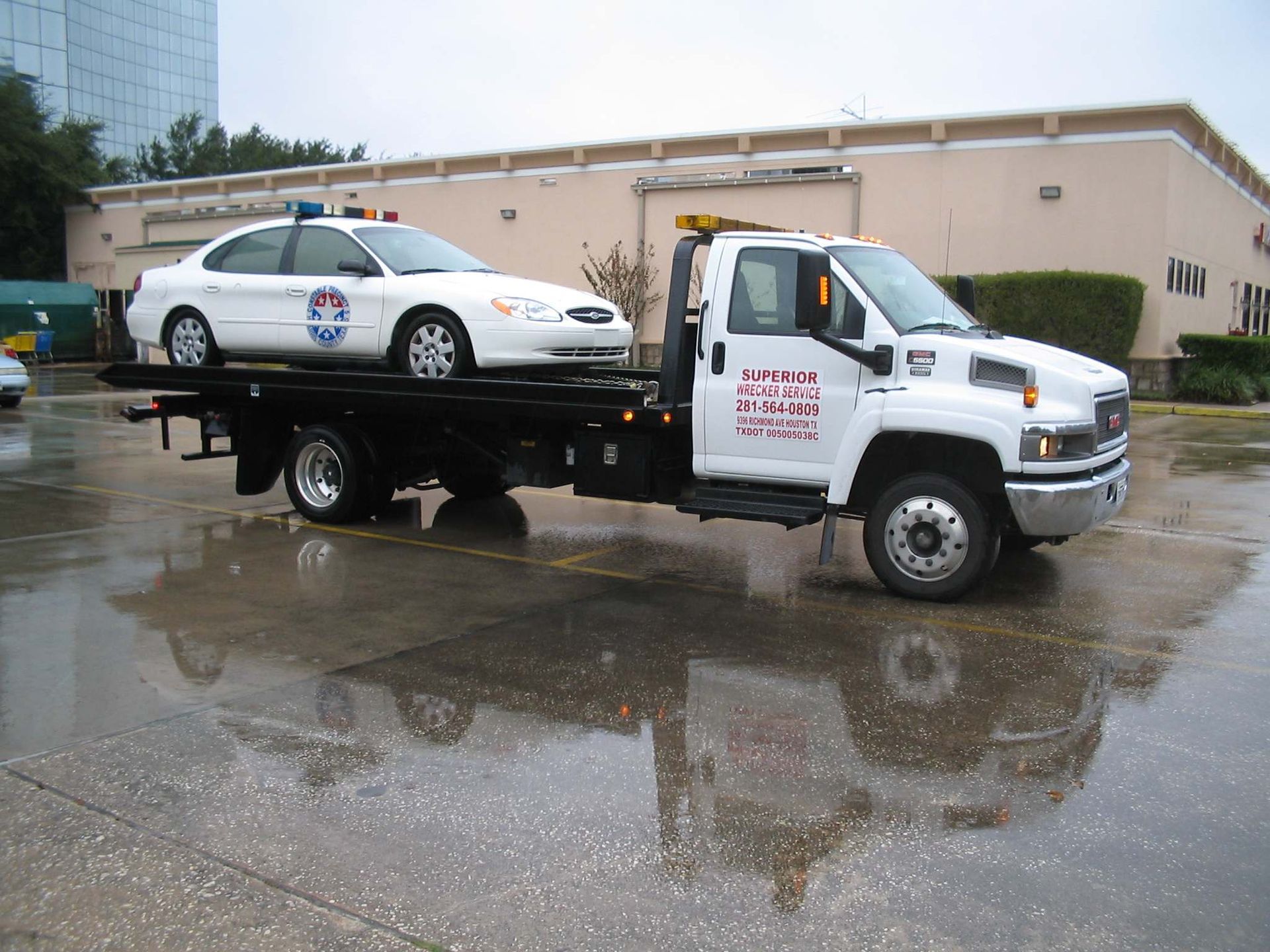 Tow truck carrying a white police car
