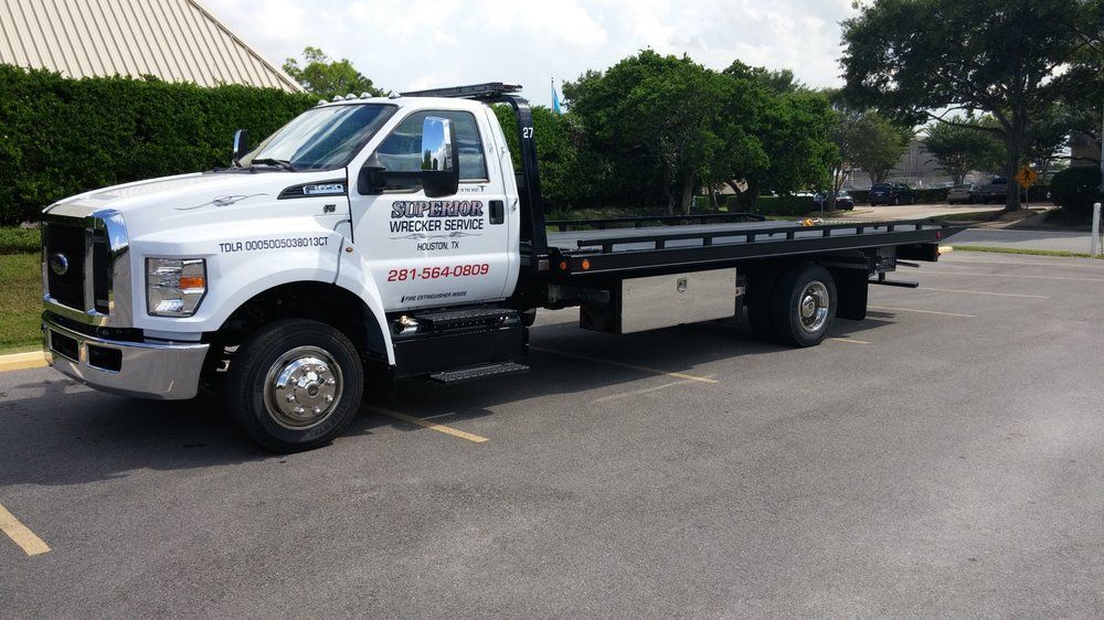 White tow truck parked in a paved lot
