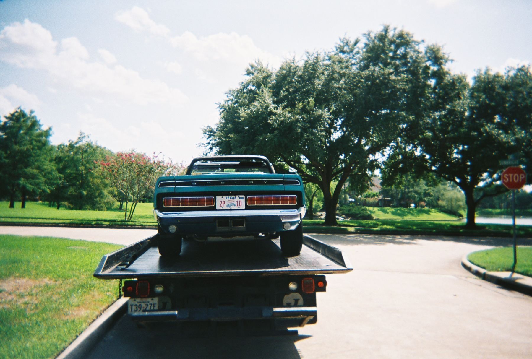 Green car on a flatbed tow truck