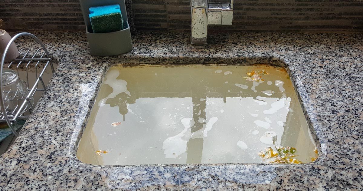 Kitchen sink overflowing with murky water and debris in dire need of clogged drain repair service Long Island