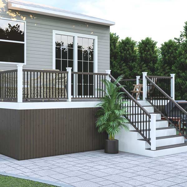 Composite deck with black and white railing, stairs, house, and a patio.
