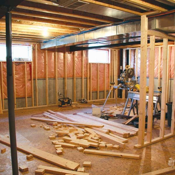 Basement under construction with exposed framing, insulation, and tools.