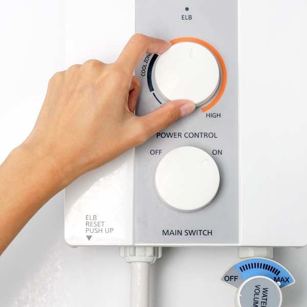 Hand turning the power control knob on a tankless boiler.