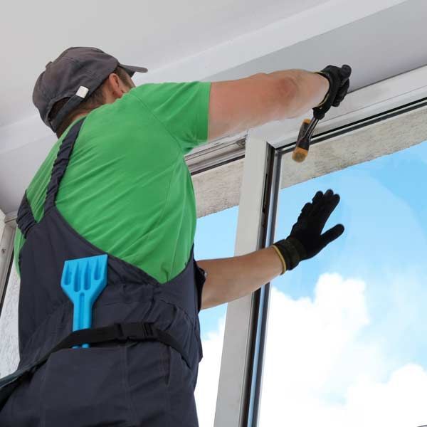 A handyman making a Windows and Doors repair