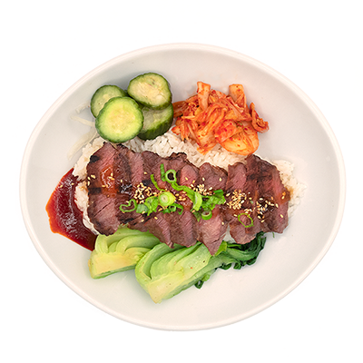 Beef bibimbap bowl with kimchi, cucumbers, bok choy, and sauce.