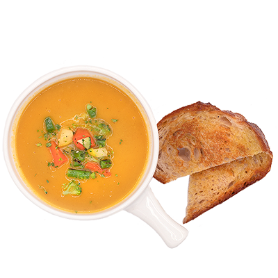 A bowl of orange soup with vegetables, and two slices of toasted bread.