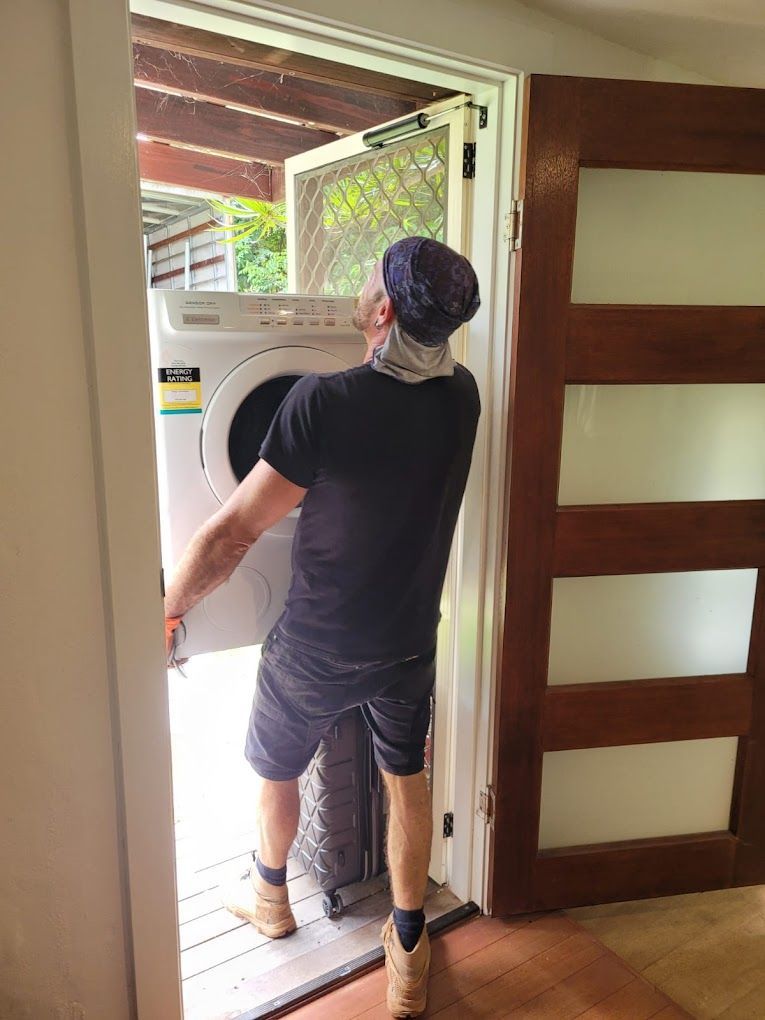 A Man is Loading a Washing Machine Into a Doorway — Ready To Move in Mullumbimby, NSW
