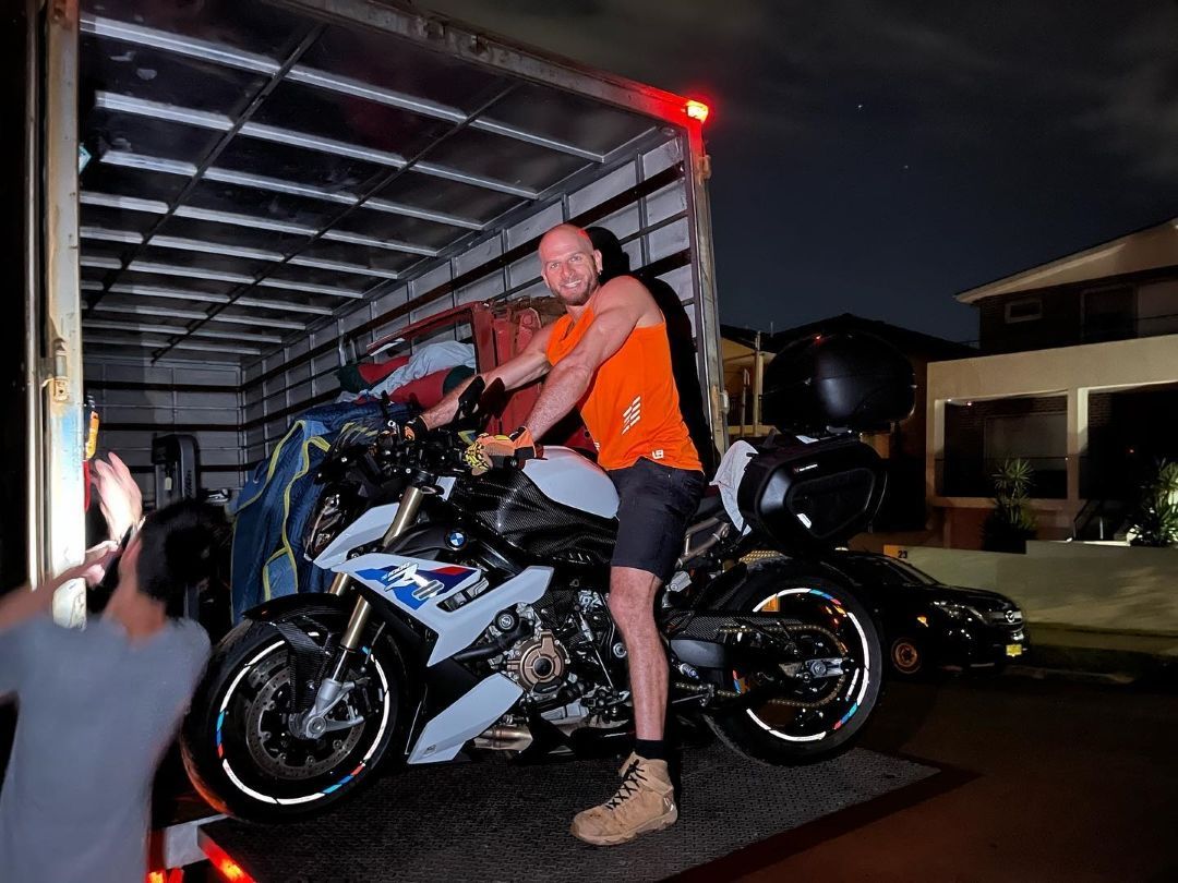A Man is Loading a Motorcycle Into a Truck — Ready To Move in Mullumbimby, NSW
