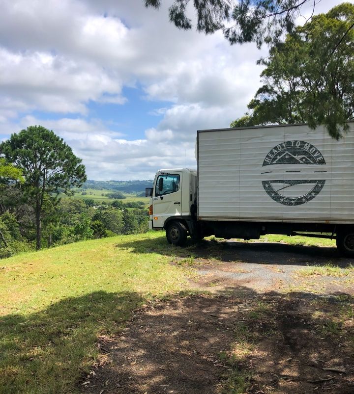 A White Branded Truck is Parked on a Grassy Hill — Ready To Move in Mullumbimby, NSW