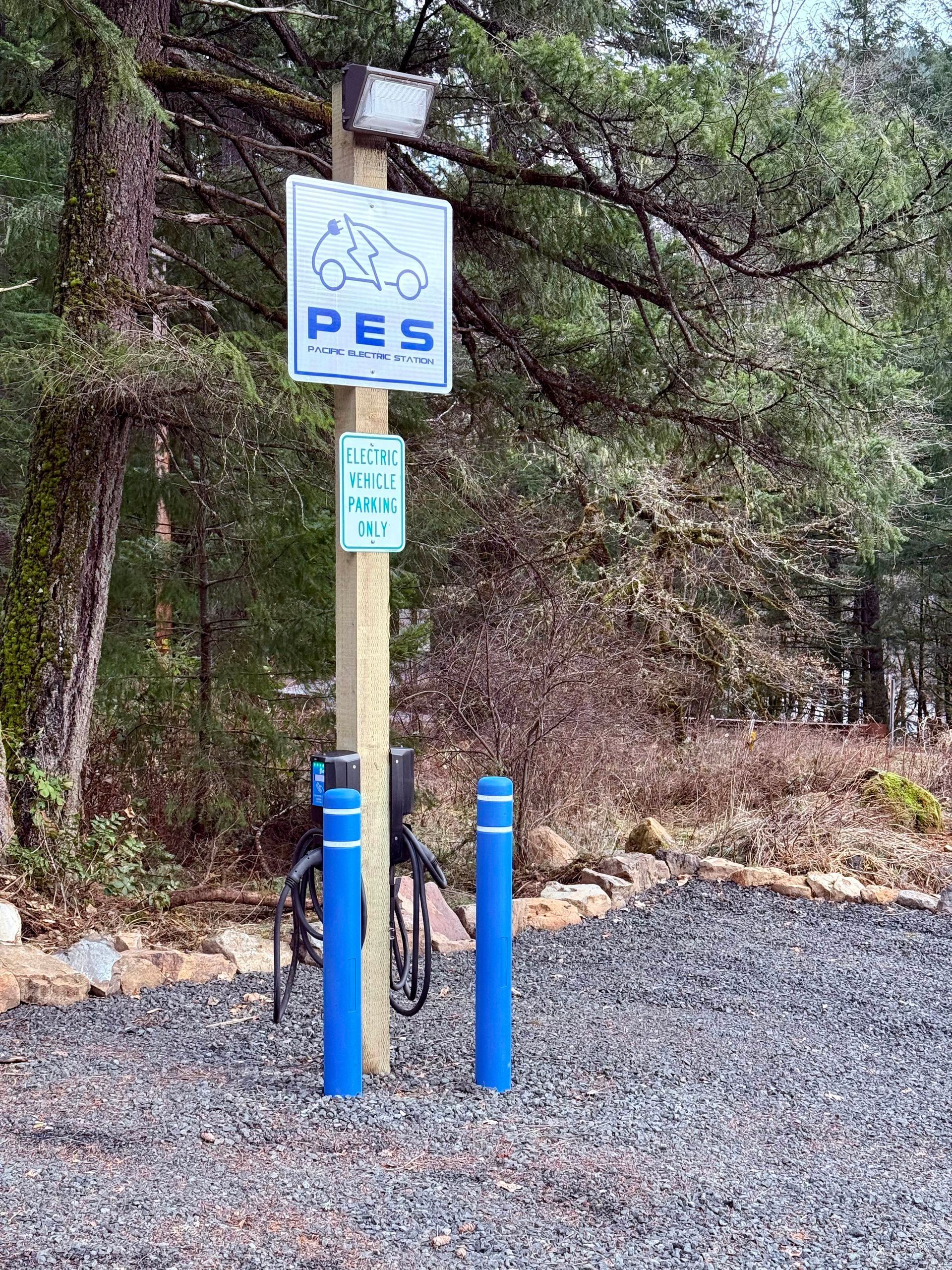 A wooden post with a sign that says pes on it.