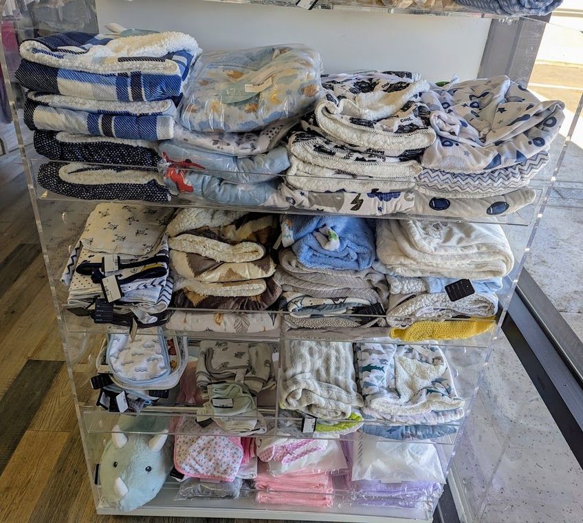 A clear display case filled with blankets and towels in a store.