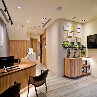 A room with a desk , chairs , and a computer.