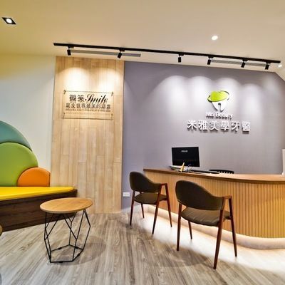 A dental office with a reception desk and chairs
