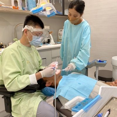 A dentist is examining a patient 's teeth in a dental office.