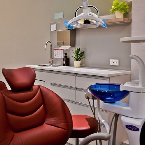 A dental office with a red chair and a sink