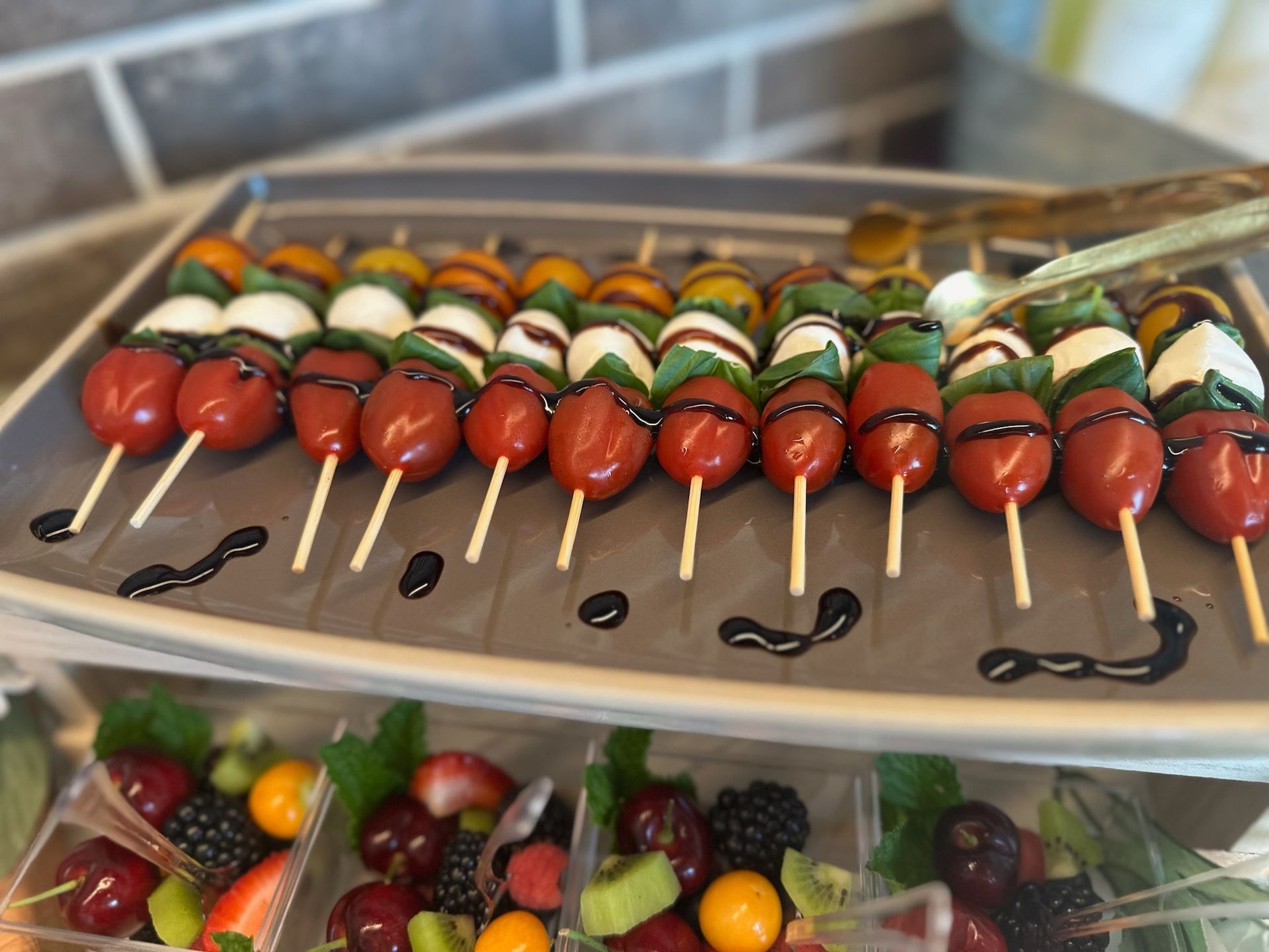 Person holding a grilled cheese sandwich, with melted cheese stretching; tomato soup bowl in foreground.