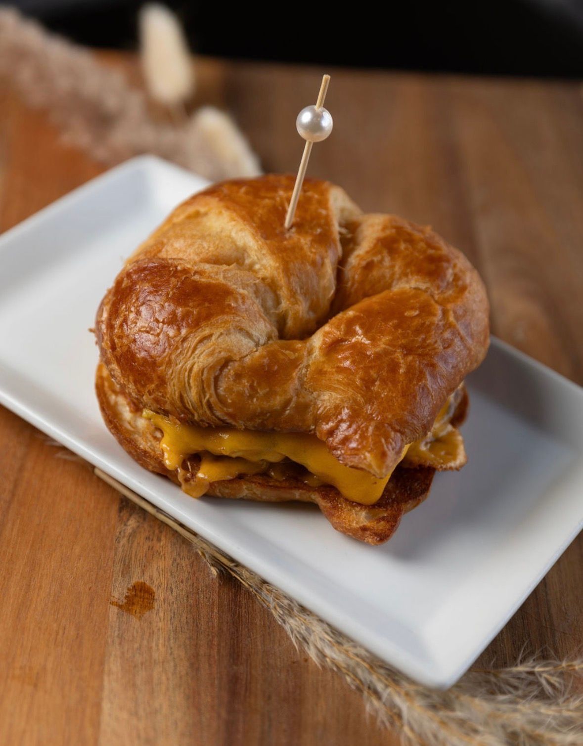 Family of four in blue and white standing on a grassy field, posing for a photo.