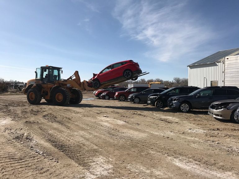 Junk Vehicles — Red Car Being Lift  in Riverton, WY