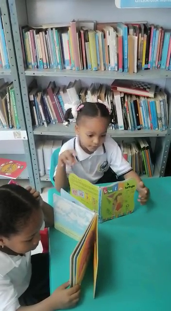Two young students reading in the library.  