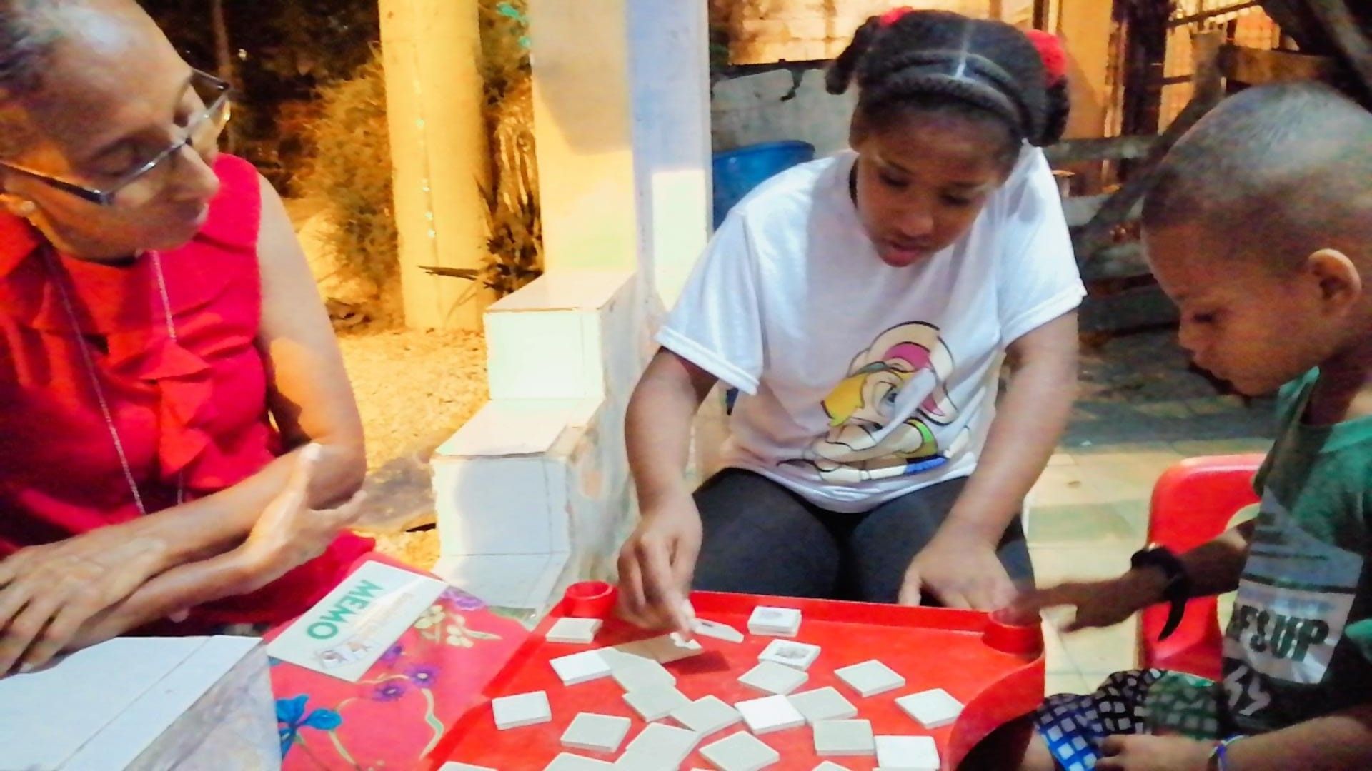Three young students playing a building block game. 