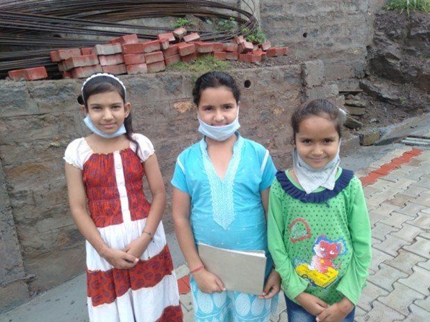 Three young girl students smiling together, getting ready for class. 