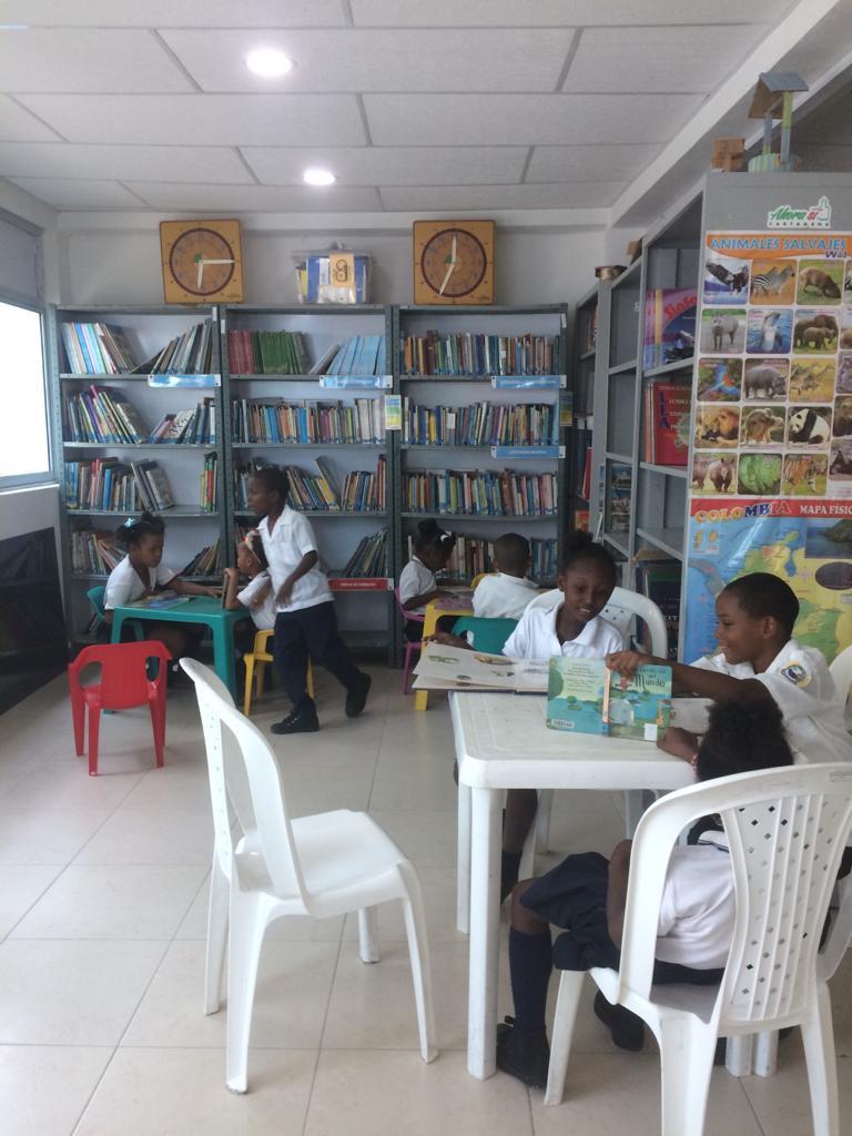 A few young students reading in their school's library. 