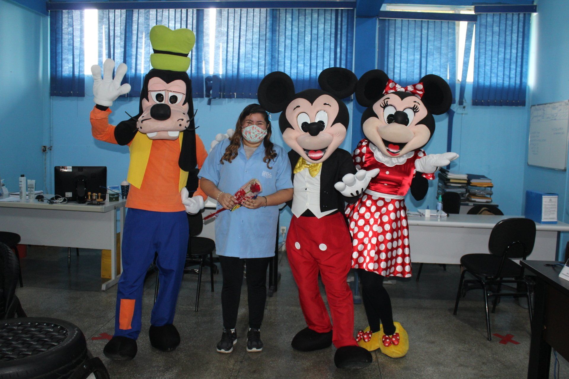 Teacher at ADCAM standing with Minnie Mouse, Mickey Mouse and Goofy (in costume). 