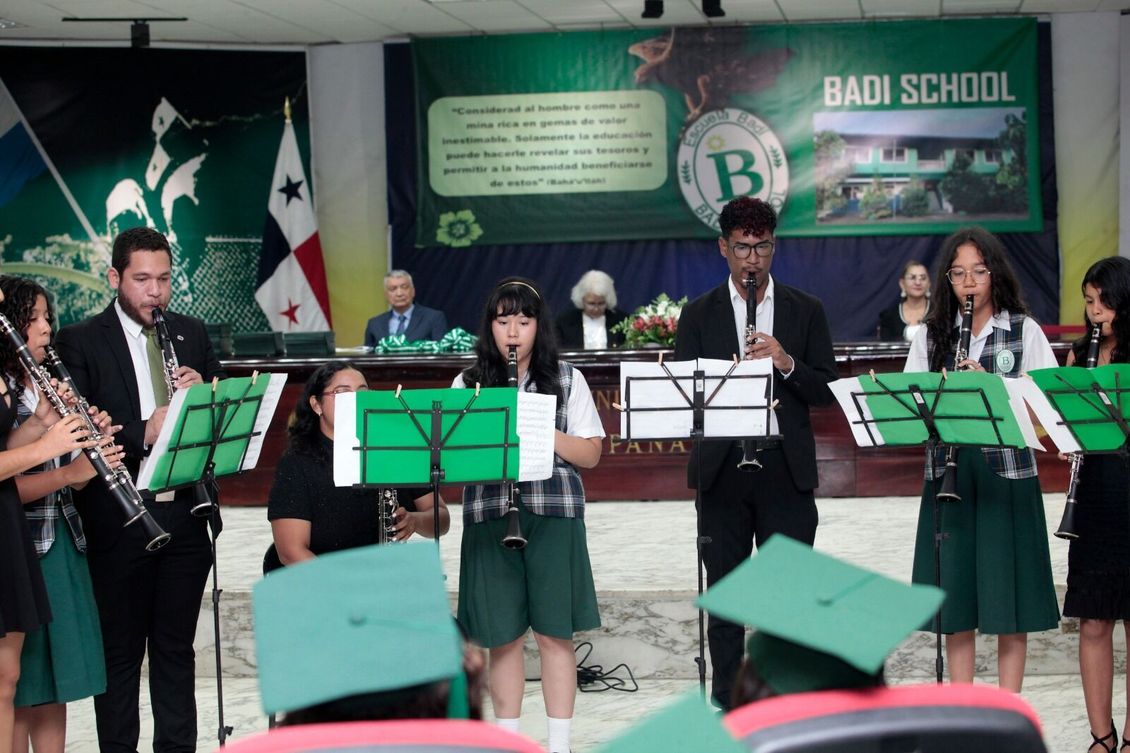 A band is performing in front of a sign that says badi school