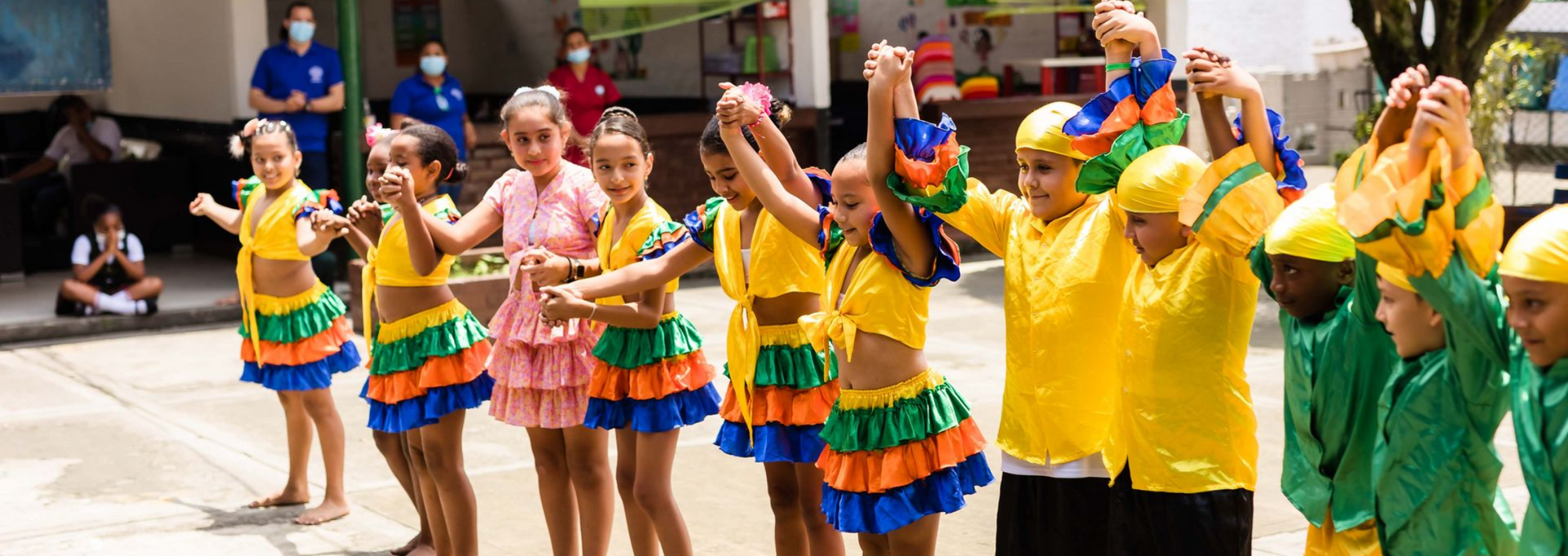 A group of children wearing red shirts are posing for a picture.