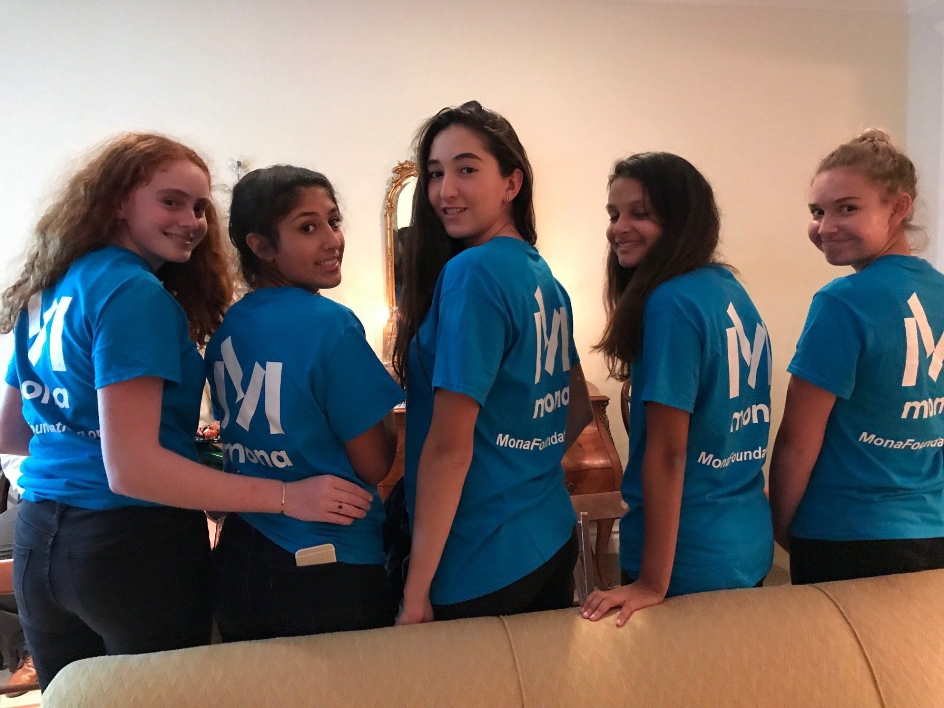 Five young girls in their Move4Mona t-shirts, posing for the camera. 