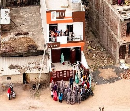 an aerial photo showing a group of people standing in front of Kali's home