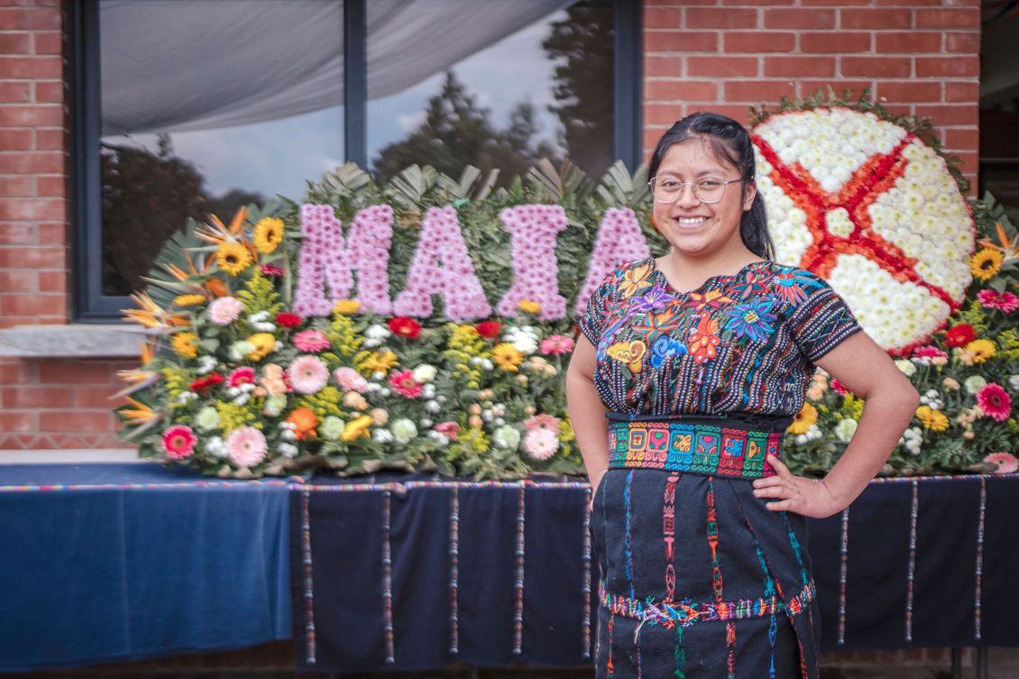 A woman is standing in front of a sign that says mata