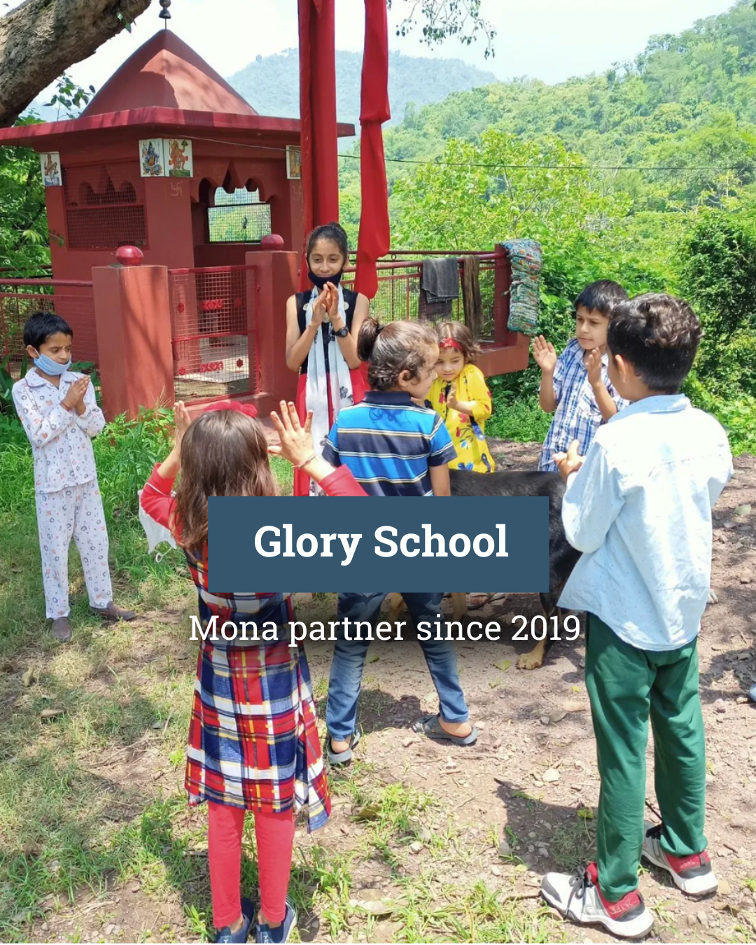 A group of children are standing in a circle in front of a temple.