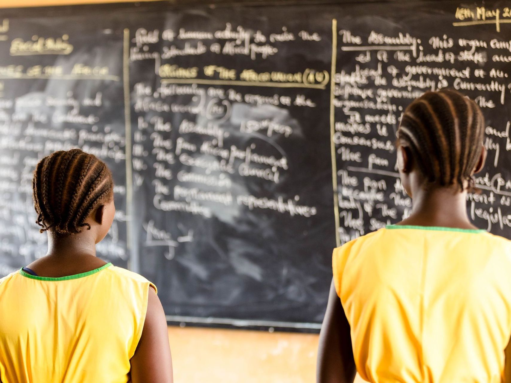Two young students looking at chalk board, at Hope Academy in Sierra Leone.