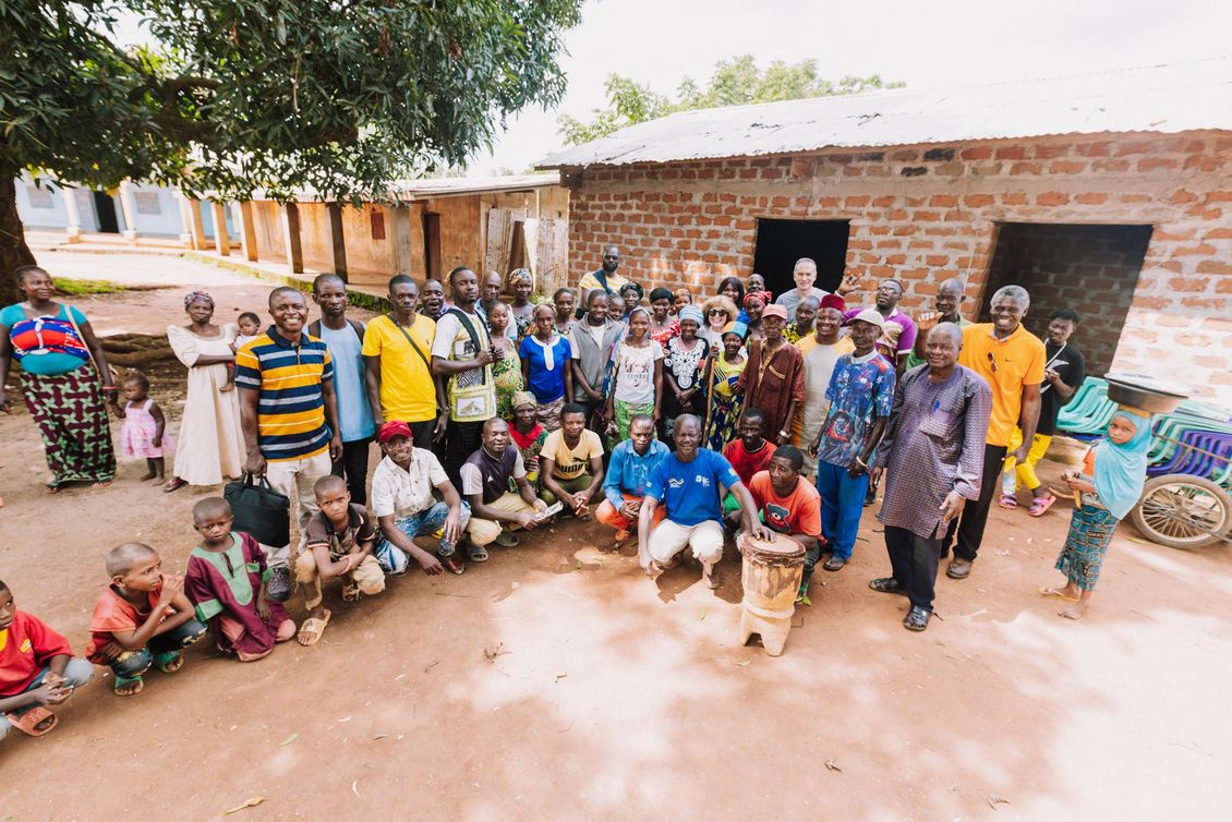 A large group of people are posing for a picture in front of a brick building.