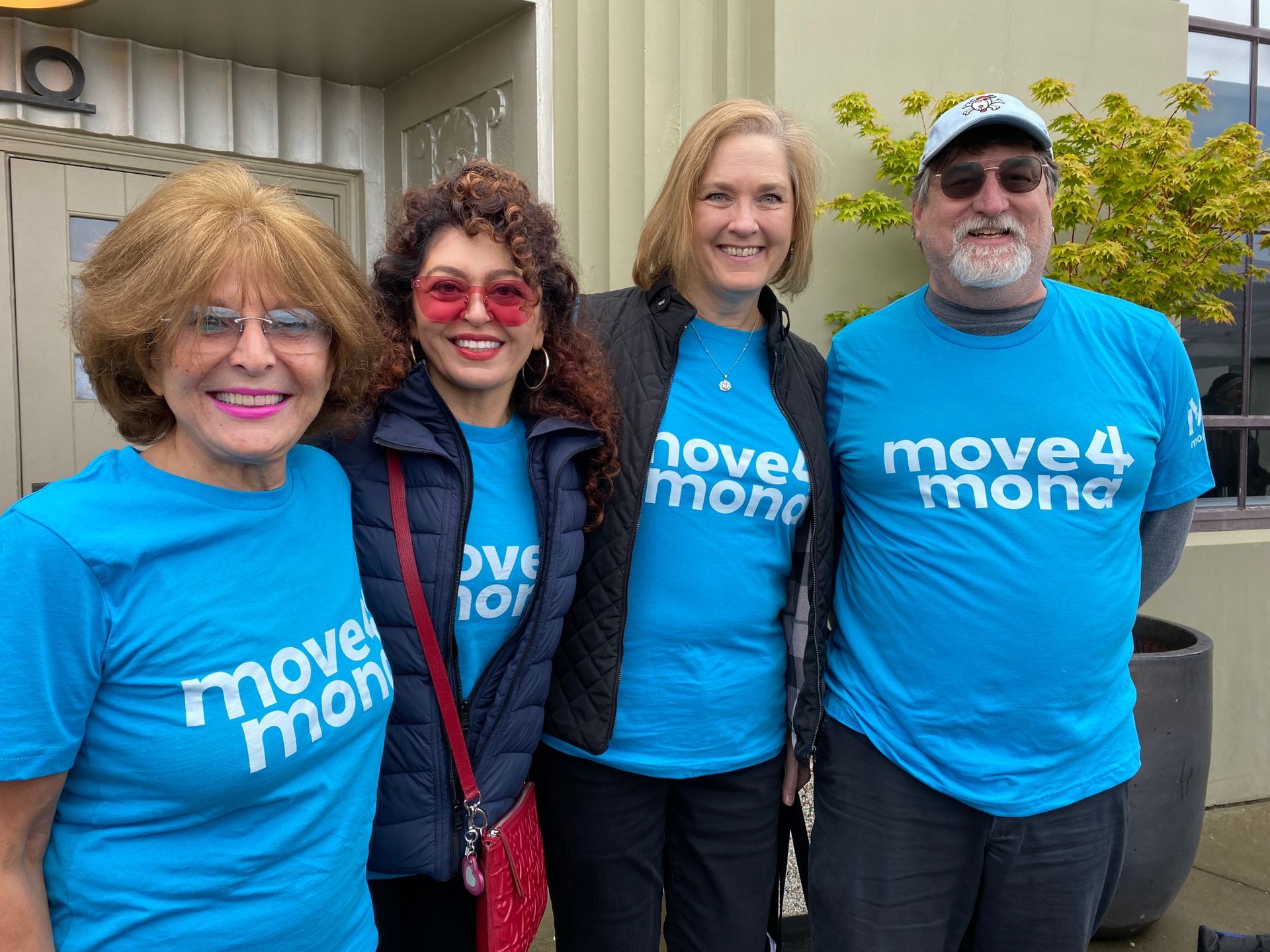 A group of people wearing blue t-shirts are posing for a picture.