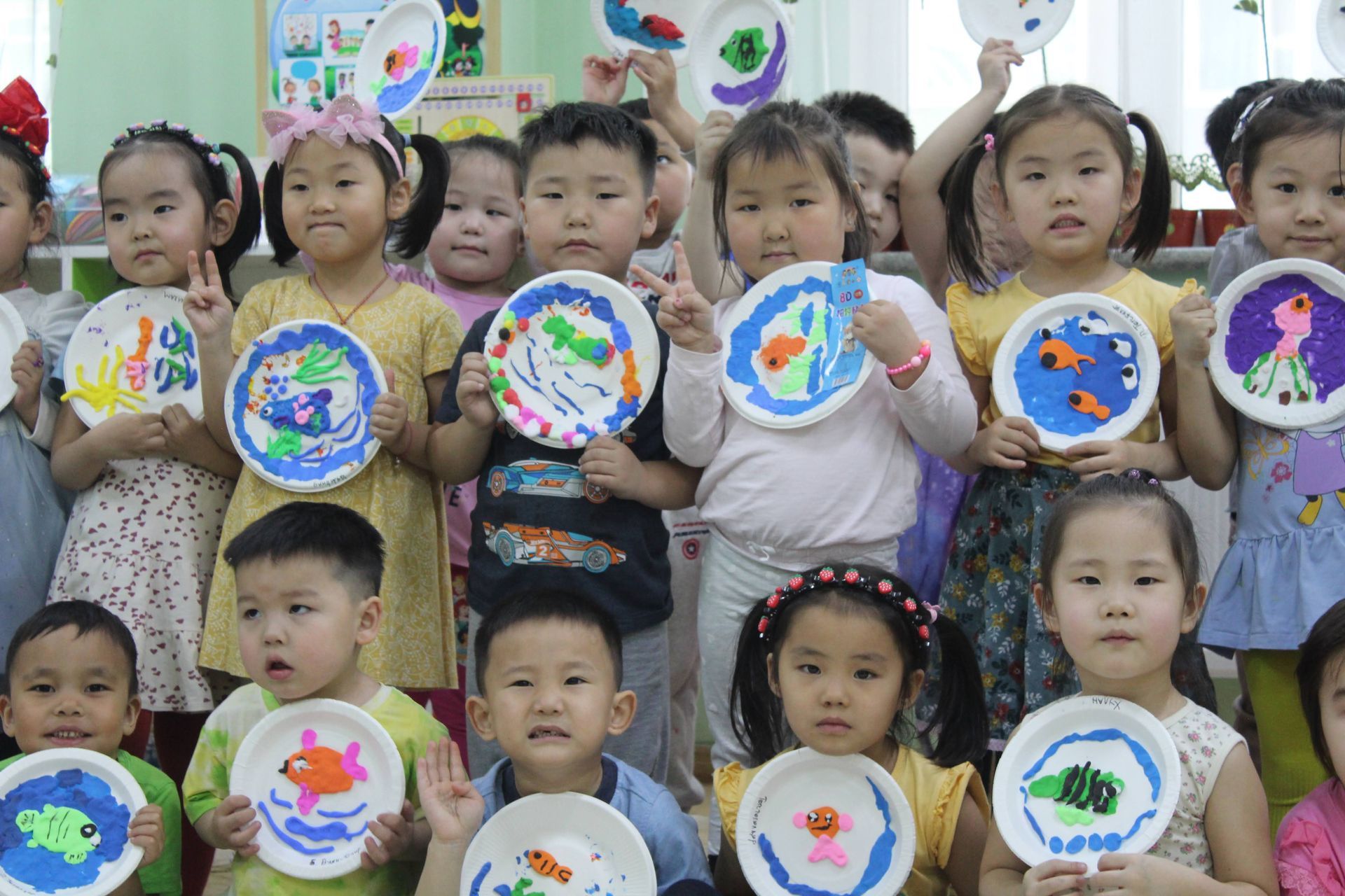 A group of Kindergarten students with their paper plate art projects. 