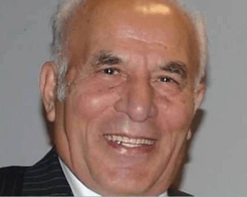 A man in a suit and tie is smiling for the camera.