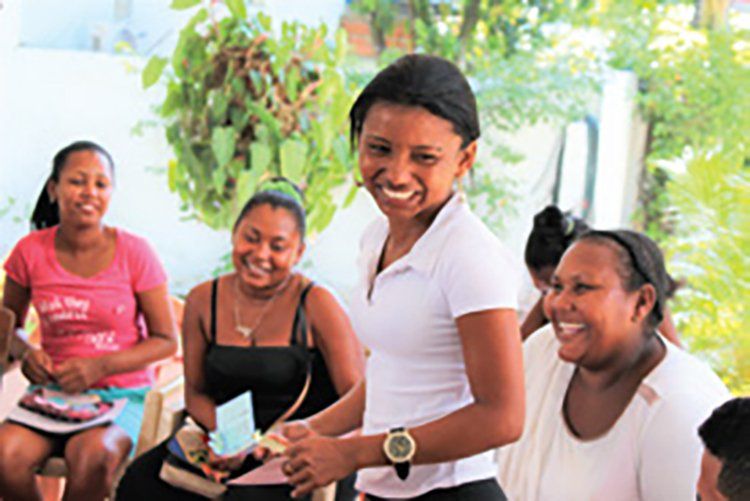 A group of women are sitting in a circle and smiling.