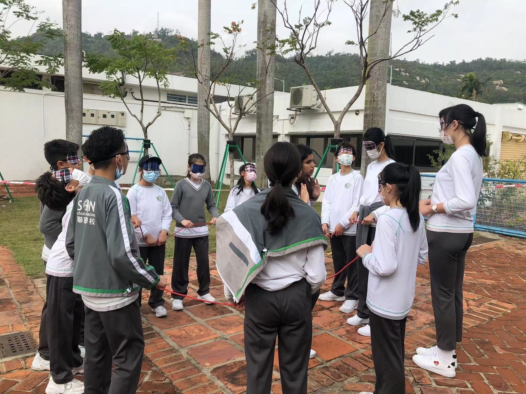 A group of students and their teacher working on a class exercise outside. 