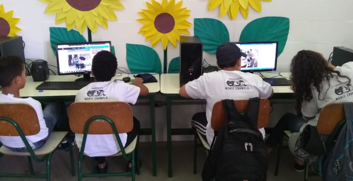 Two students working on their computers at their desk. 