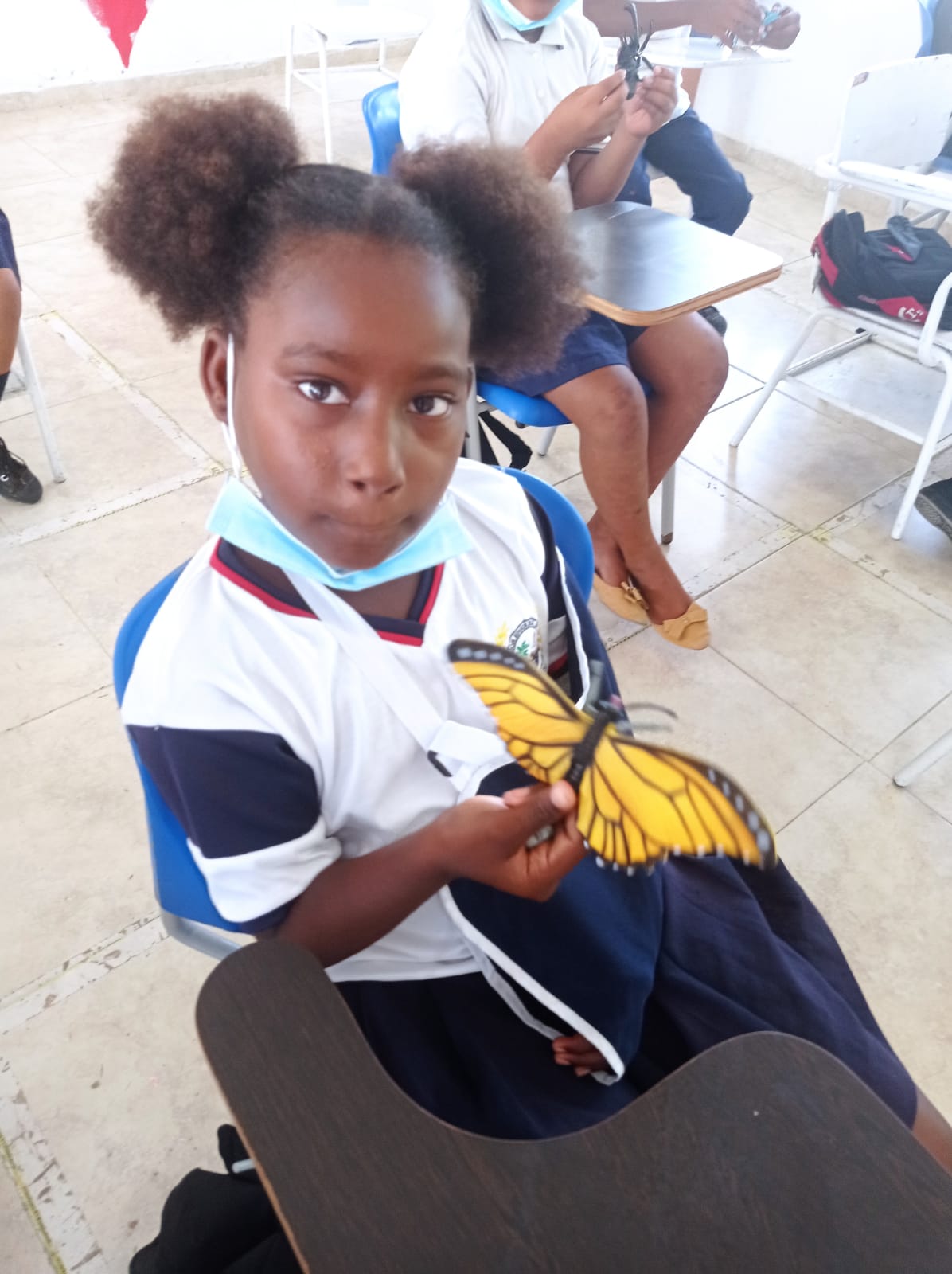 A young girl student with butterfly art she made. 