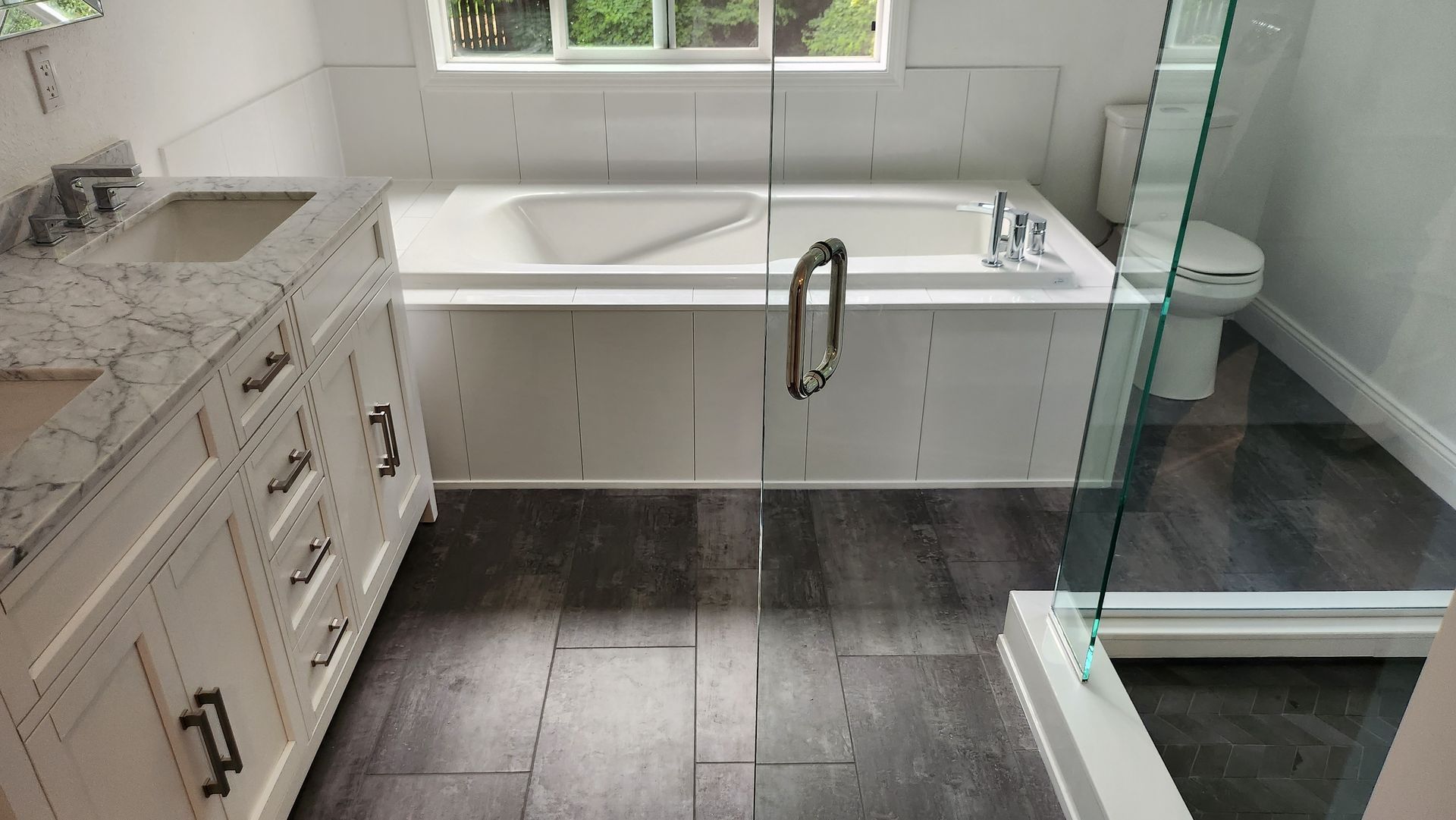 A bathroom with a tub , sink , toilet and shower.
