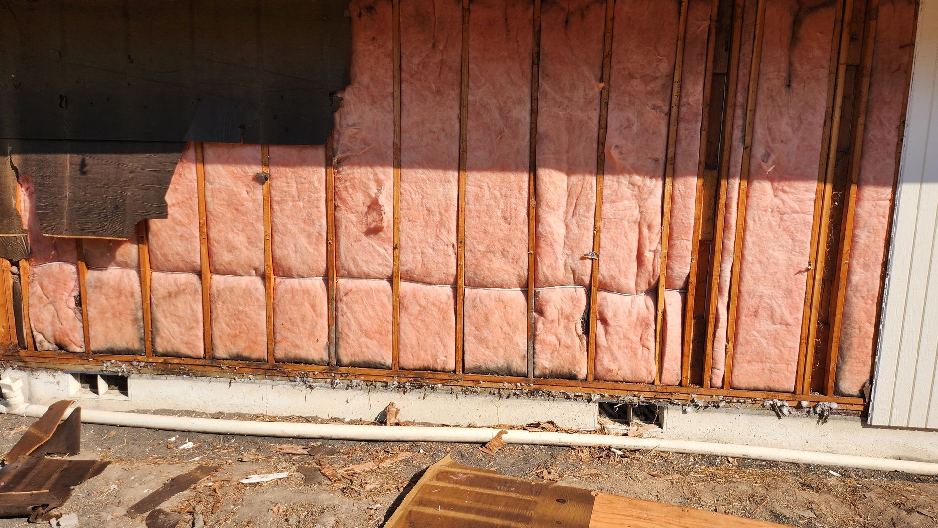 A wall with a lot of insulation on it is being demolished.