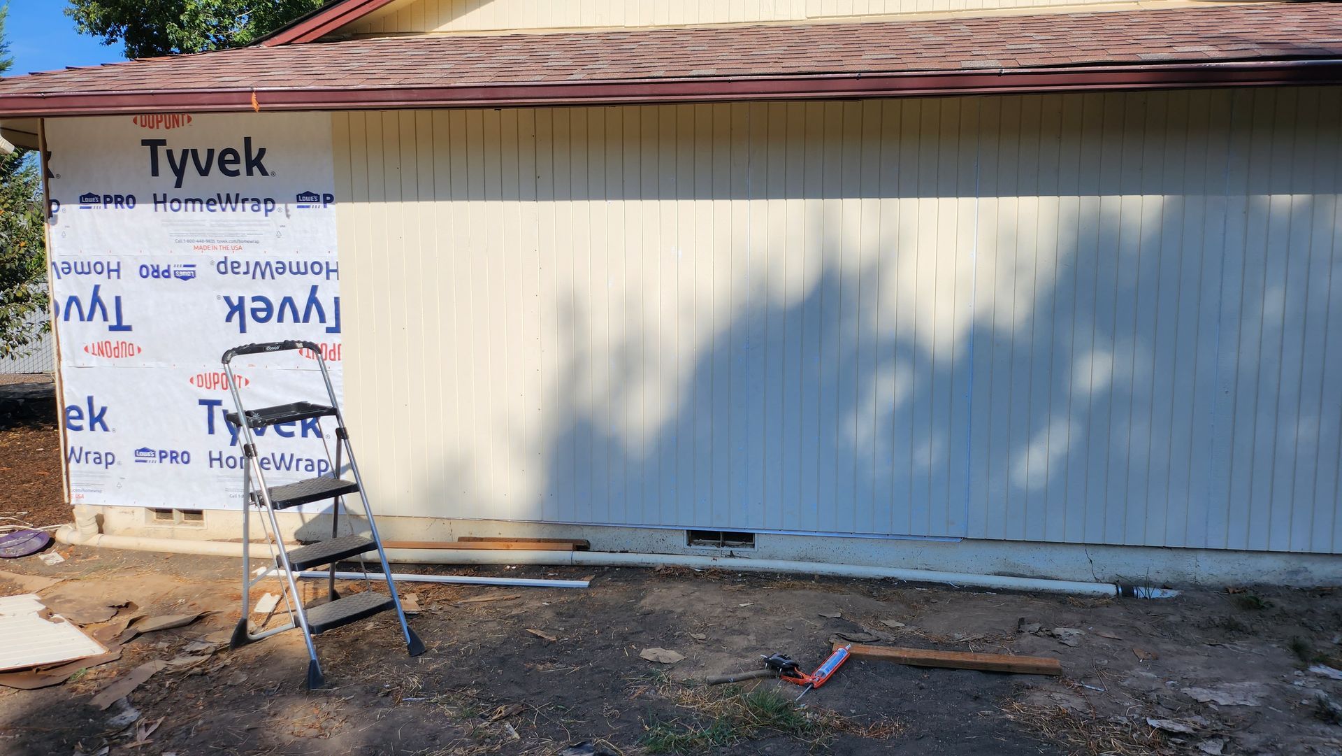 A ladder is sitting in front of a garage door that is being installed.