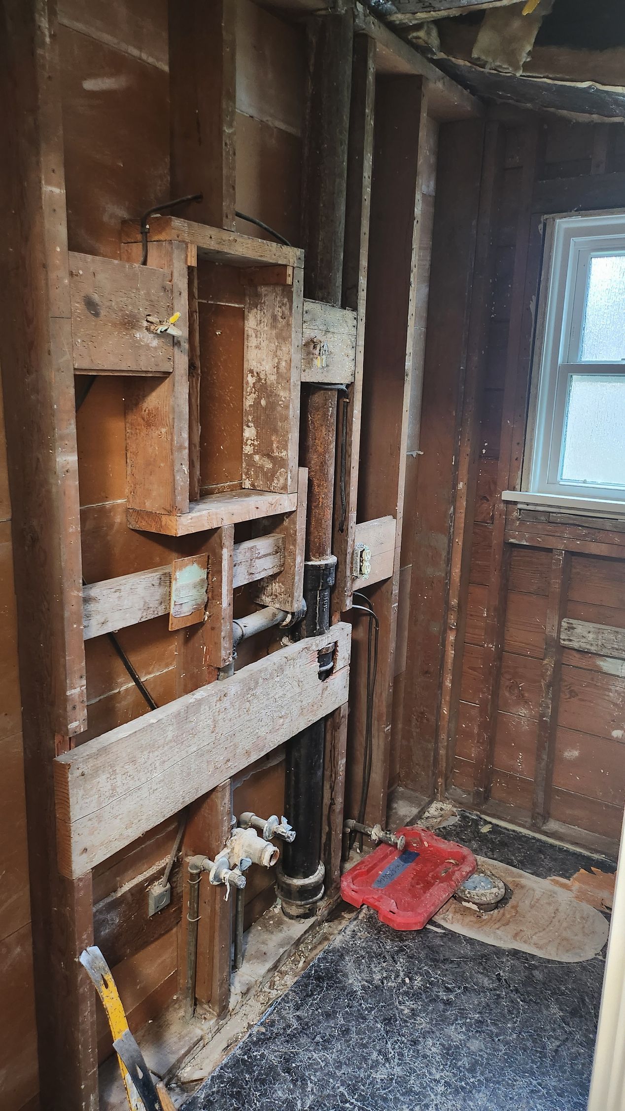 A bathroom under construction with a sink and a window.
